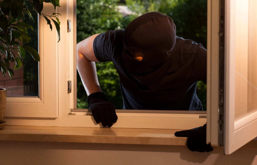 burglar trying to climb through window